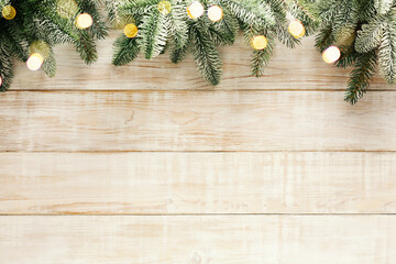 Christmas tree branches and bokeh lights on wooden background. Christmas Holiday background, Copy space.