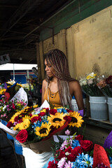 a beautiful Afro-descendant woman choosing some flowers in the middle of the city of San José in Costa Rica