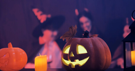 Falling pumpkins decorate the Halloween party venue. Group of friends party over wine and food Have...