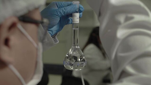 An analyst measures and places the mixed components to form a regulated pill.
