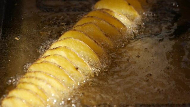 fried chips potatoes frying in boiling hot oil in a deep fryer,