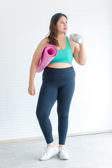 Asian young sexy chubby fat female fit model in sports bra legging sneakers standing posing holding...