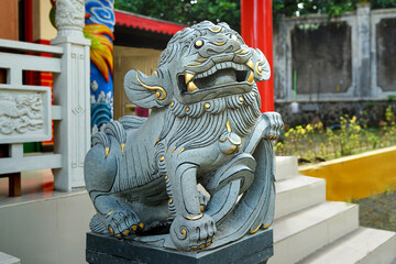Chinese guardian lion. People were visiting and praying. Located in front of the temple - Powered by Adobe