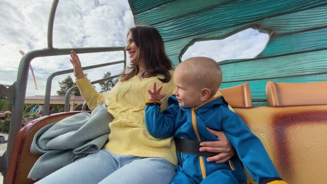 mother with child enjoy views of amusement park from height of 4 meters, traveling in a mobile, Divo Ostrov, St. Petersburg, Russia