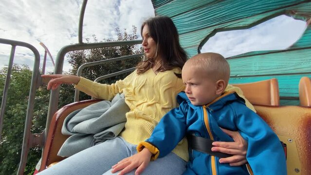 mother with child enjoy views of amusement park from height of 4 meters, traveling in a mobile, Divo Ostrov, St. Petersburg, Russia