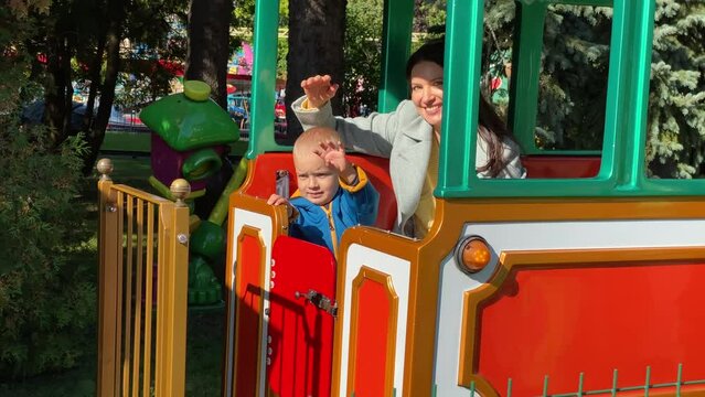 mother with toddler child in amusement park Divo Ostrov, St. Petersburg, Russia, attraction train Chukh-chukh