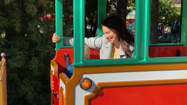mother with toddler child in amusement park Divo Ostrov, St. Petersburg, Russia, attraction train Chukh-chukh