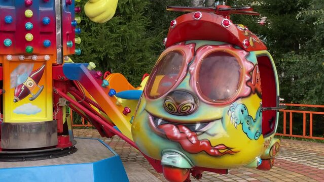 brave pilot toddler child in amusement park, attraction colorful airplanes will lift children Divo Ostrov, St. Petersburg, Russia
