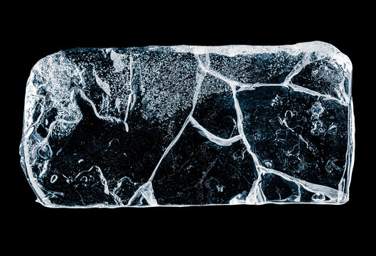 Ice piece with cracks. A rectangular block of ice isolated on a black background.