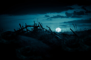 Horror night landscape with an old broken fence under the full moon. Halloween background.