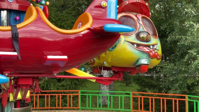 brave pilot toddler child in amusement park, attraction colorful airplanes will lift children Divo Ostrov, St. Petersburg, Russia