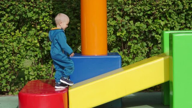 toddler child in amusement park, happy little boy climbing on colorful cubes. Divo Ostrov, St. Petersburg, Russia