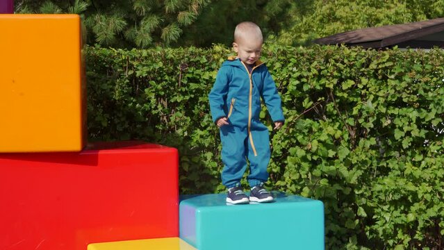 toddler child in amusement park, happy little boy climbing on colorful cubes. Divo Ostrov, St. Petersburg, Russia