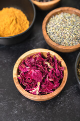 Obraz na płótnie Canvas Herbal skincare ingredients in wooden bowls on a black background