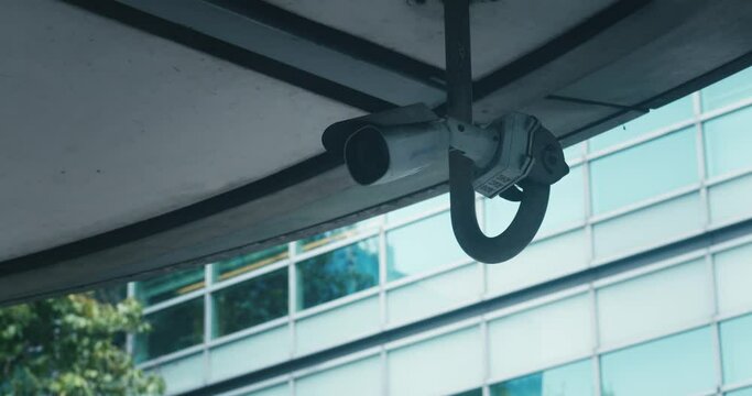 Video surveillance camera system installed on city streets. Cctv camera security system scanning street in big city. Security video camera at the corner of building moving and scanning street area