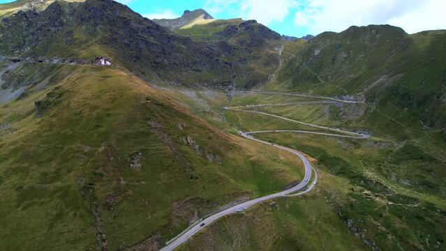 Gentle pullback parallax as passenger cars traverse across Transfagarasan Serpentine Road