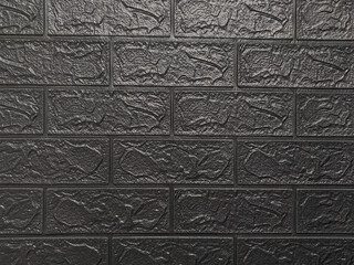 Black brick wall with gray background.