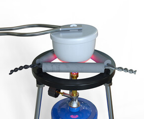 3D illustration of a crucible being heated strongly using a Bunsen burner.  The crucible lid is slightly lifted with tongs.