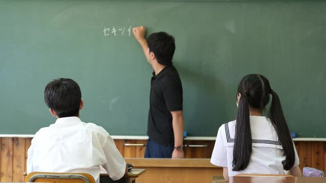 学校の教室の教壇に立つ男性教師