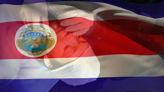 Animation of waving costa rica flag over doctor placing oxygen mask on a female patient at hospital