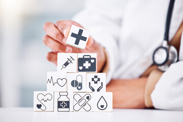 Hands, medical and a building blocks in a hospital with a doctor closeup for health insurance. Healthcare, icon and symbol with a medicine professional and tower in clinic for cardiology or treatment