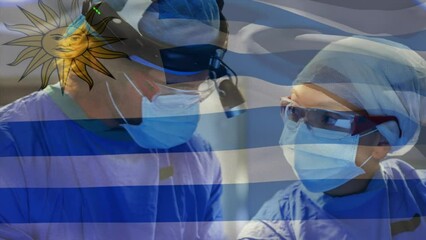 Animation of uruguay flag against diverse male and female surgeons performing operation at hospital - Powered by Adobe