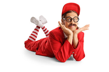 Funny entertainer in a red suit laying on the floor and looking at camera