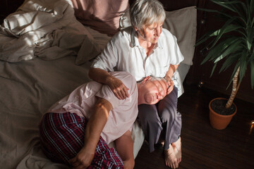 Worried senior woman embracing upset old man