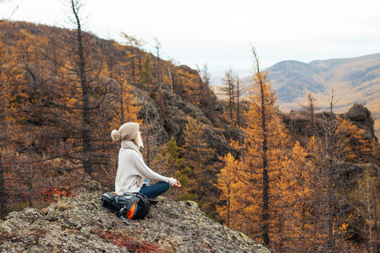 Woman doing meditation yoga exercise and relaxing in the mountains