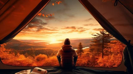 Keuken spatwand met foto Traveler holding relaxing inside a orange tent and enjoy the view of sunset on autumn forest in national park Generative ai © StockWorld