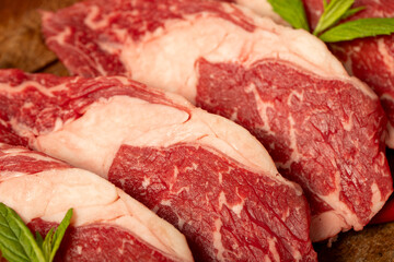 Veal entrecote meat on wood background. Raw beef rib eye steak with herbs and spices. Close up
