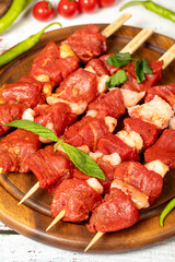 Beef tenderloin skewer on wood background. Beef tenderloin skewer with raw sauce with herbs and spices. Close up