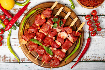Beef tenderloin skewer on wood background. Beef tenderloin skewer with raw sauce with herbs and spices. Top view