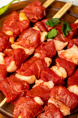 Beef tenderloin skewer on wood background. Beef tenderloin skewer with raw sauce with herbs and spices. Close up