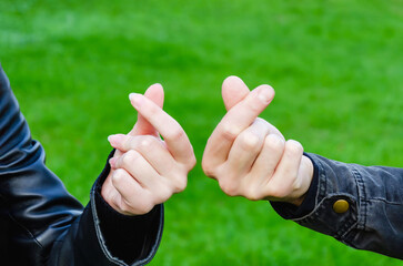 male and female hand make heart gesture with your fingers. Couple in Love Made Korean Love Sign