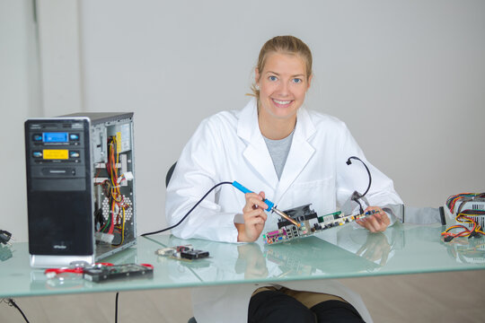 a lady soldering components of a pc