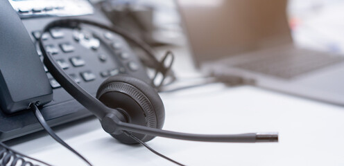 close up black headset with telephone in operation room to communicate with client for call center and hotline service concept - obrazy, fototapety, plakaty