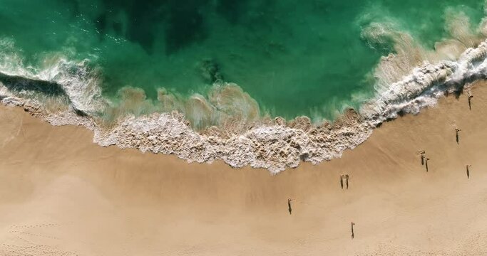 Aerial view waves break on white sand beach. Sea waves on the beautiful beach aerial view drone 4k shot. Beautiful of sea water wave come to beach.