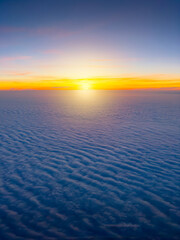 Fototapeta premium Sunrise seen from a airplane flying above the clouds