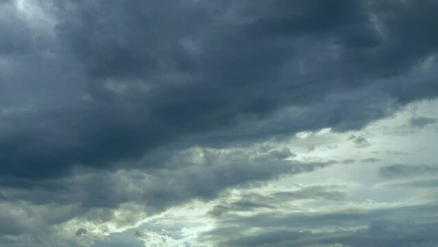 Dramatic cloudscape time lapse. Dark scene with white grey clouds
