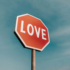 Obraz premium A passionate love-filled sky of red and white proudly hangs overhead, beckoning onlookers to pause and take in its bold outdoor signage that is rooted firmly in the street