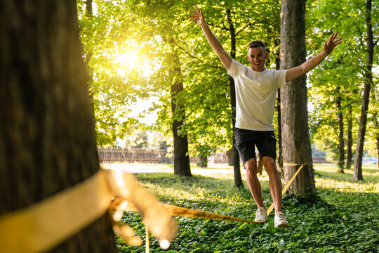 Man in sportswear doing slacklining in the forest