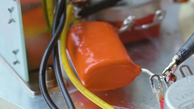 Guitar service concept. Man soldering potentiometer contact on electric guitar with soldering iron. 4k video footage 3840x2160
