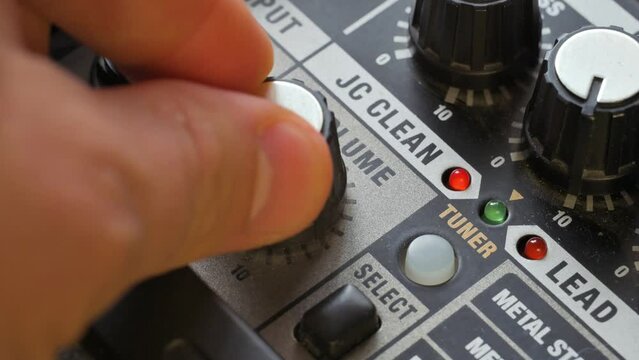 Man tuning equilizer knob on guitar amplifier. 4k video footage UHD 3840x2160