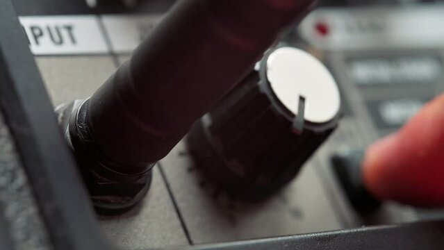 Man plug in jack and tuning volume knob on guitar amplifier. 4k video footage UHD 3840x2160