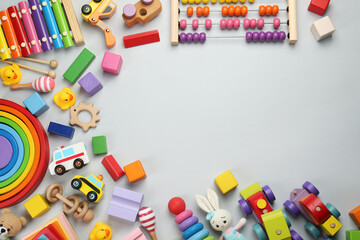 Frame of different children's toys on light grey background, flat lay. Space for text