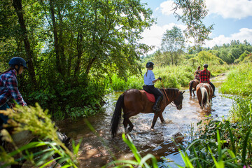 Horse ride, young girls riders, crossing a river, a stream on horseback, splashes from horse...