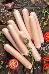 Fresh sausages on a wooden board. vertical image. top view. place for text
