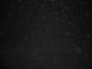 Abstract background image, blurred, bokeh, raindrops, black background.