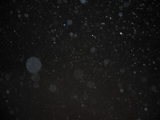 Abstract background image, blurred, bokeh, raindrops, black background.